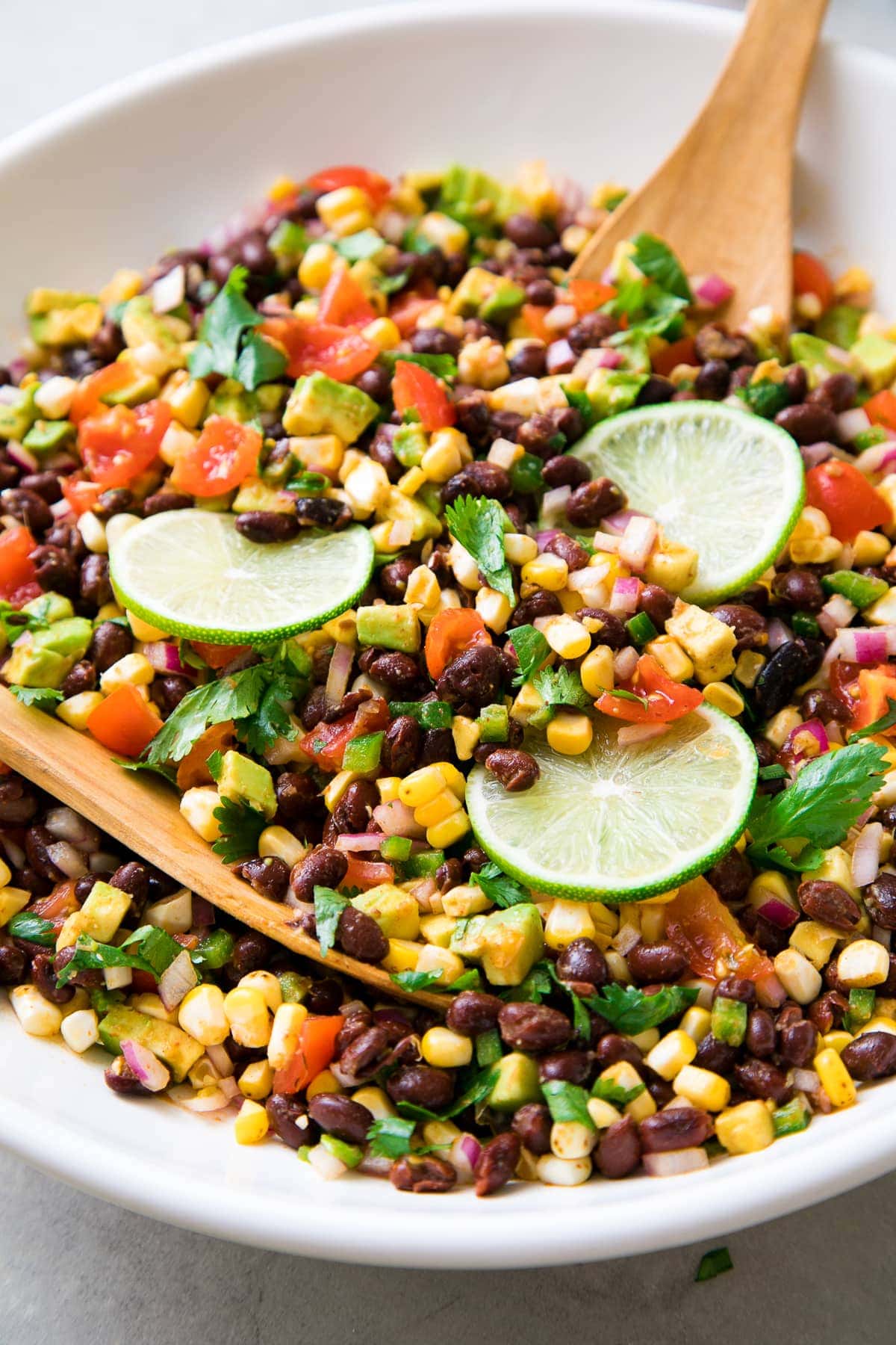 side angle view of black bean corn salad in a white bowl.