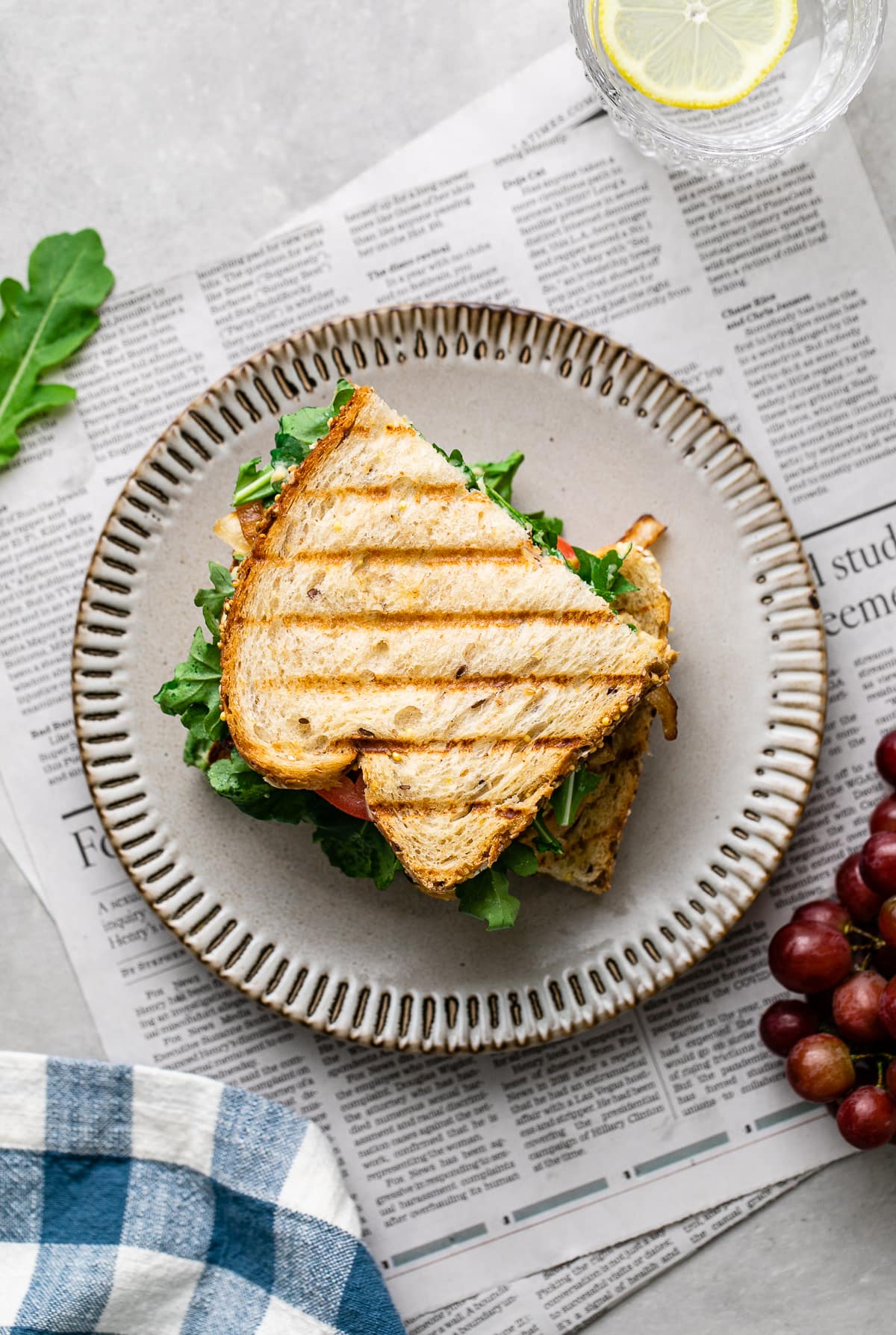 top down view of two halves of grilled hummus sandwich stacked on a small plate.