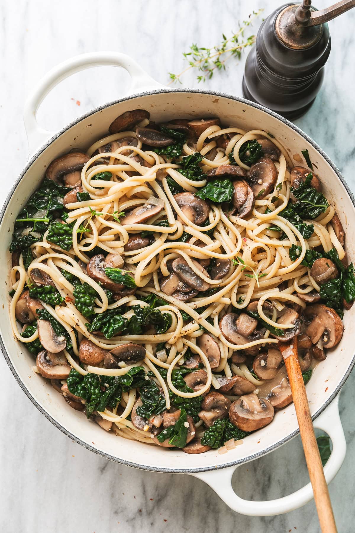 top down view of white pot with freshly made kale and mushroom pasta.