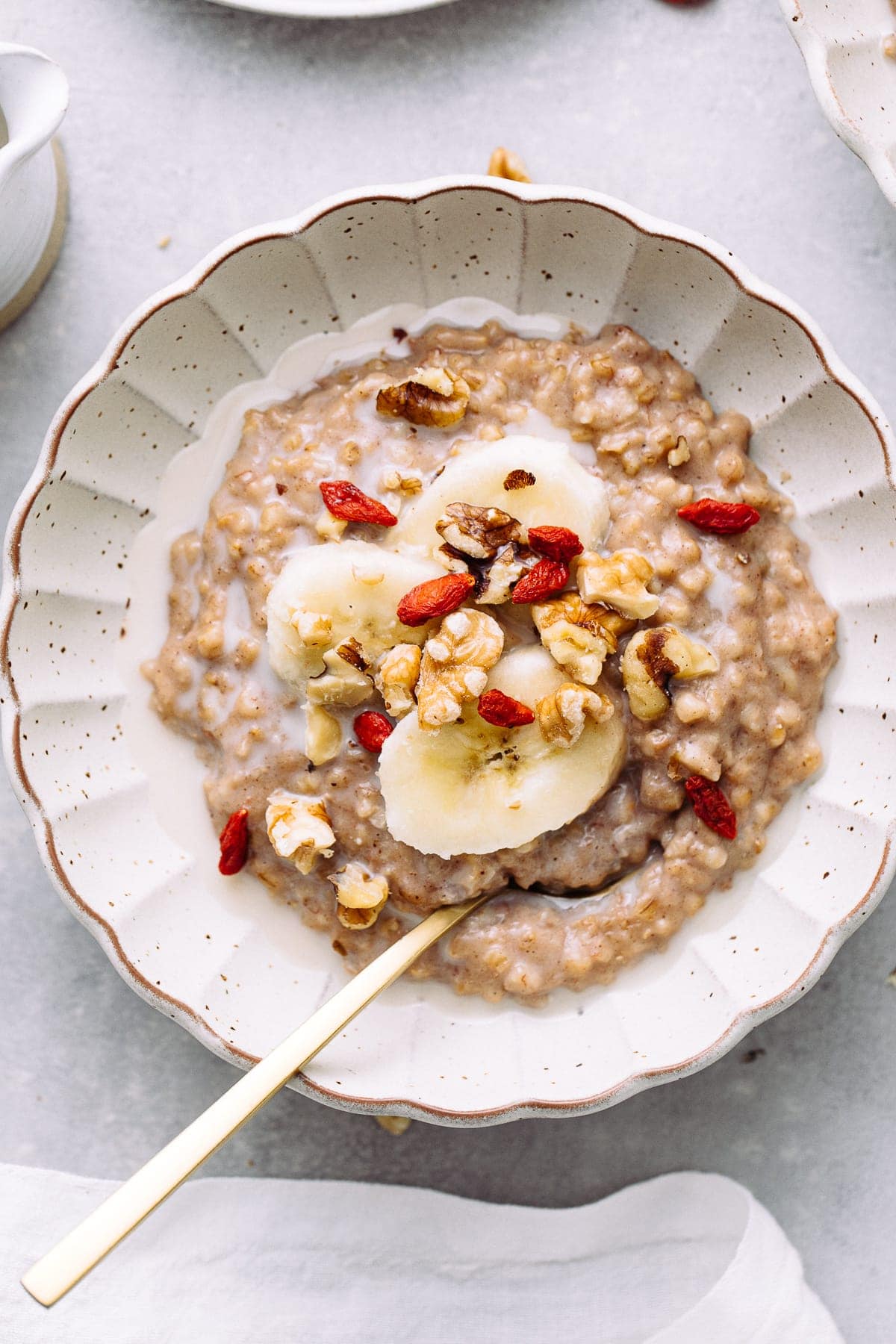 top down view of bowl with banana overnight steel cut oats with items surrounding.