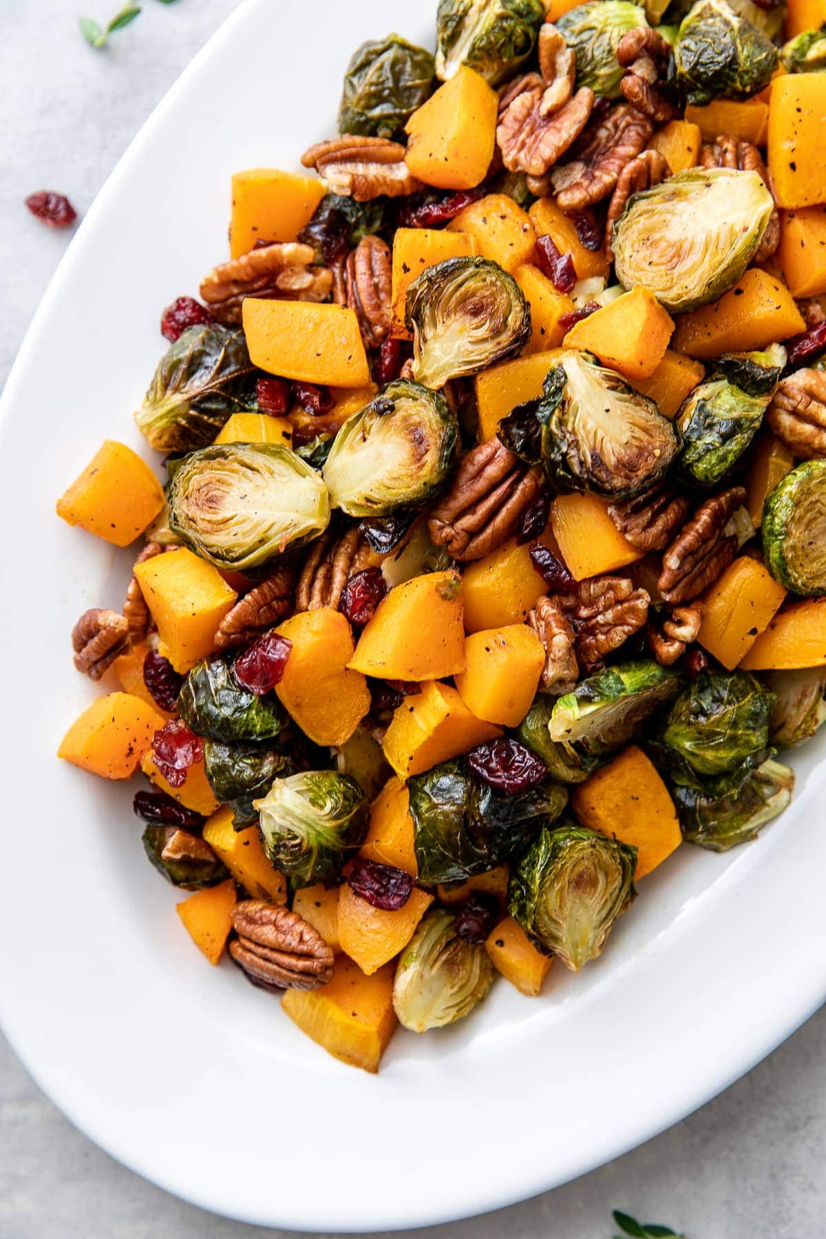top down view of serving platter with roasted brussels sprouts and butternut squash with cranberries and pecans.