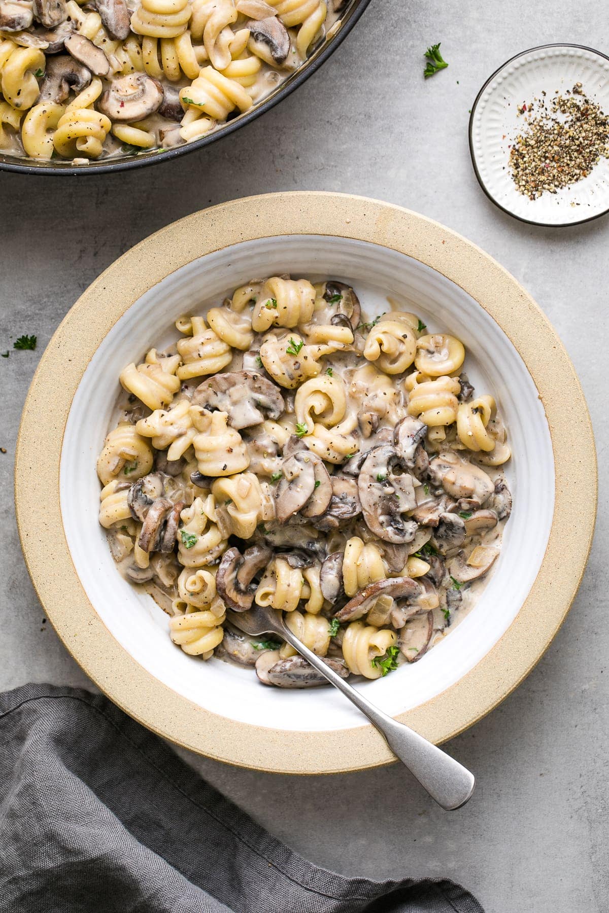 top down view of bowl with serving of vegan mushroom stroganoff with fork and items surrounding.