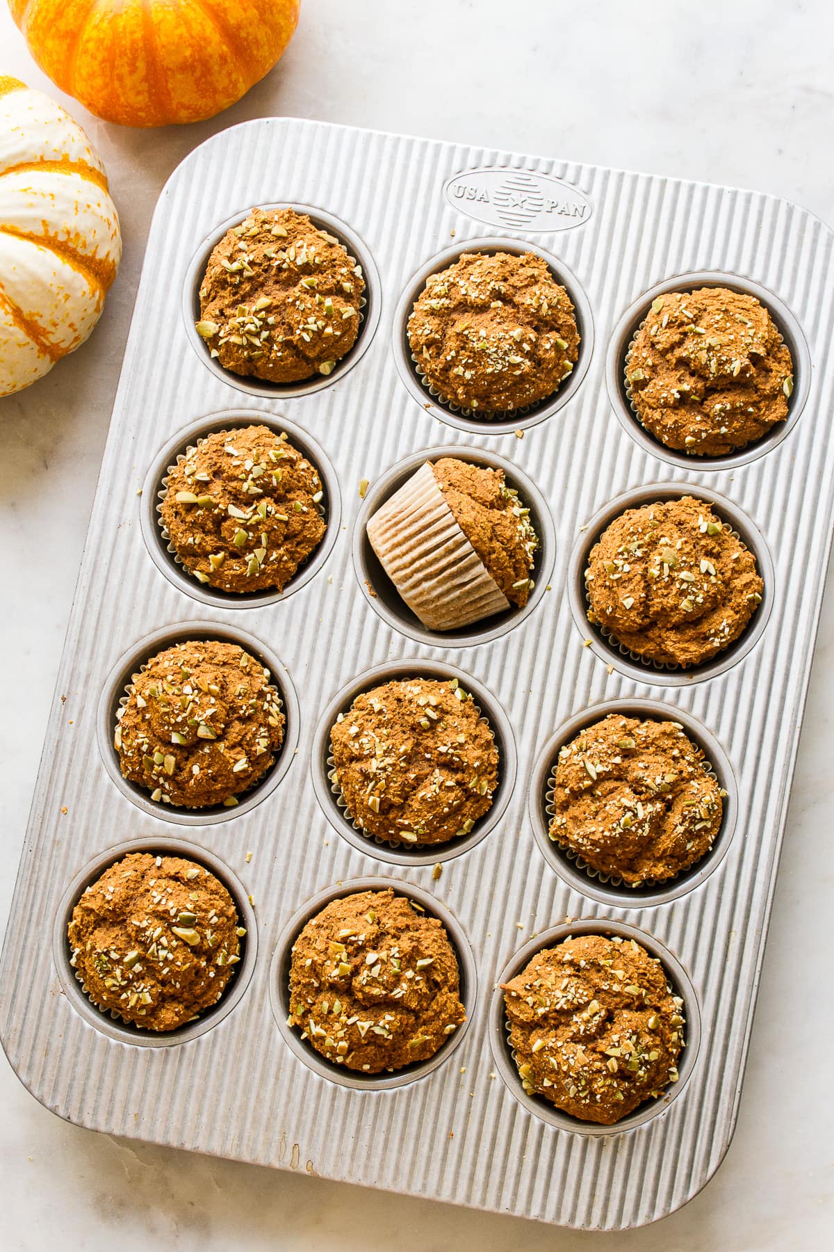 top down view of freshly baked vegan pumpkin muffins in a muffin tin.