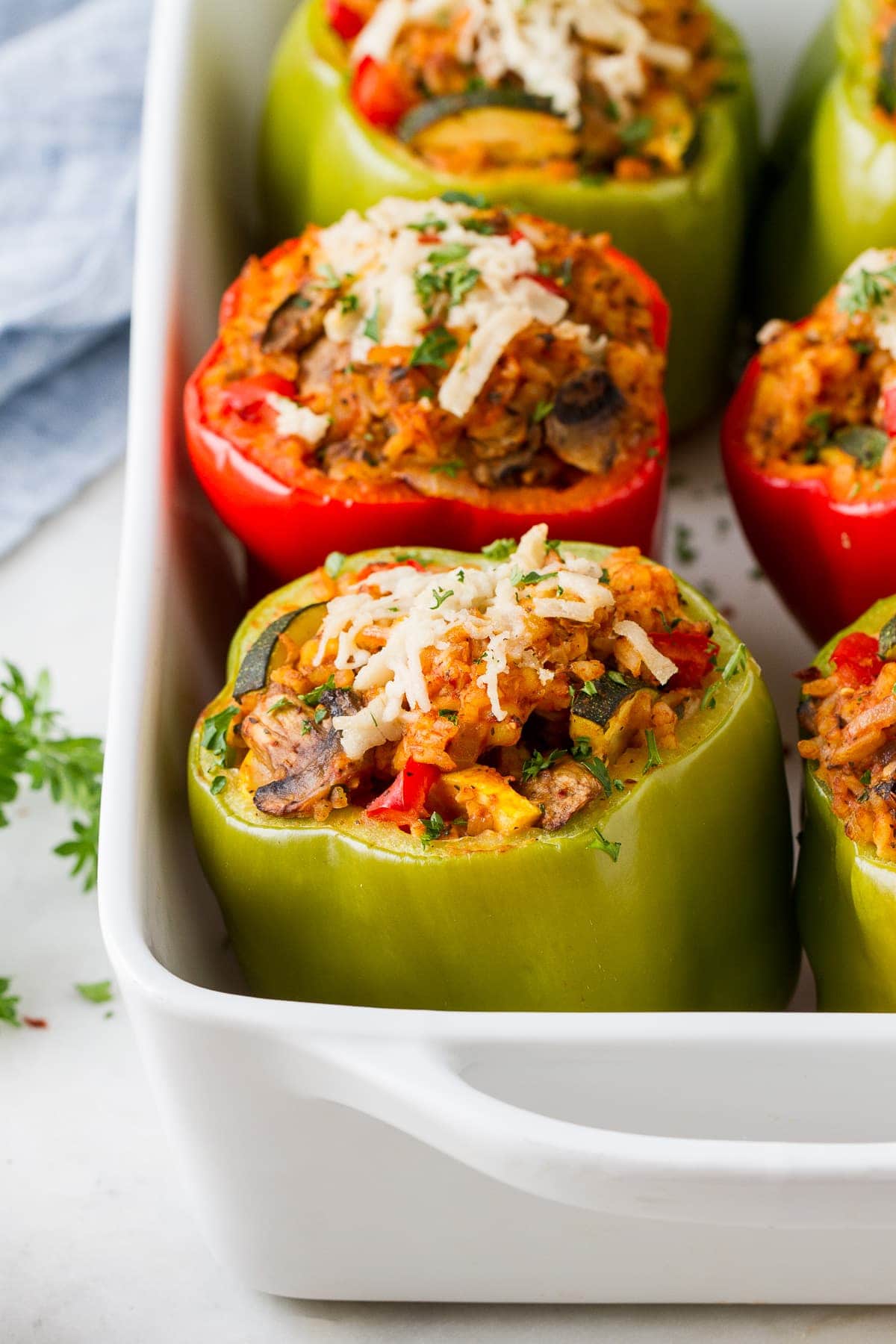side angle view of vegan stuffed bell peppers freshly baked in a baking dish.