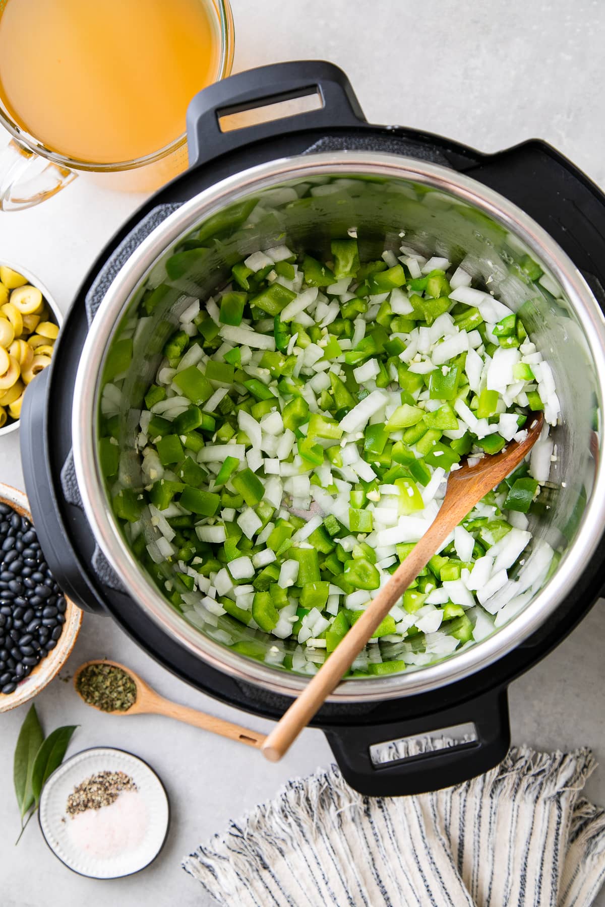 top down view of onion and bell pepper sauteed in instant pot with items surrounding.