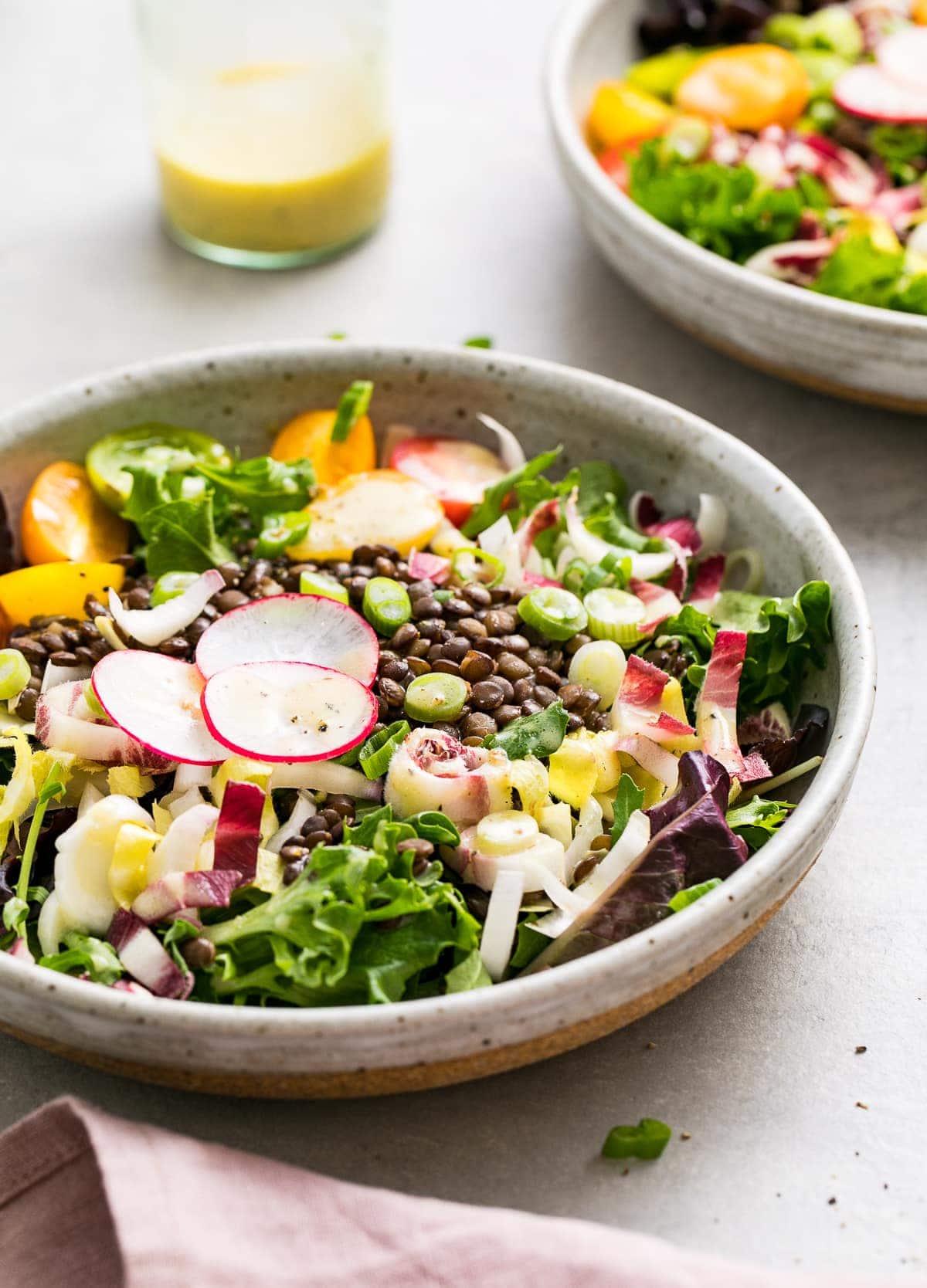 side angle view of french lentil and bitter greens salad in a bowl.