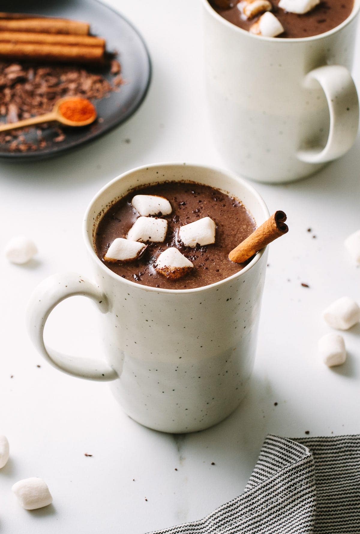 side angle view of Mexican hot chocolate in a mug with items surrounded.