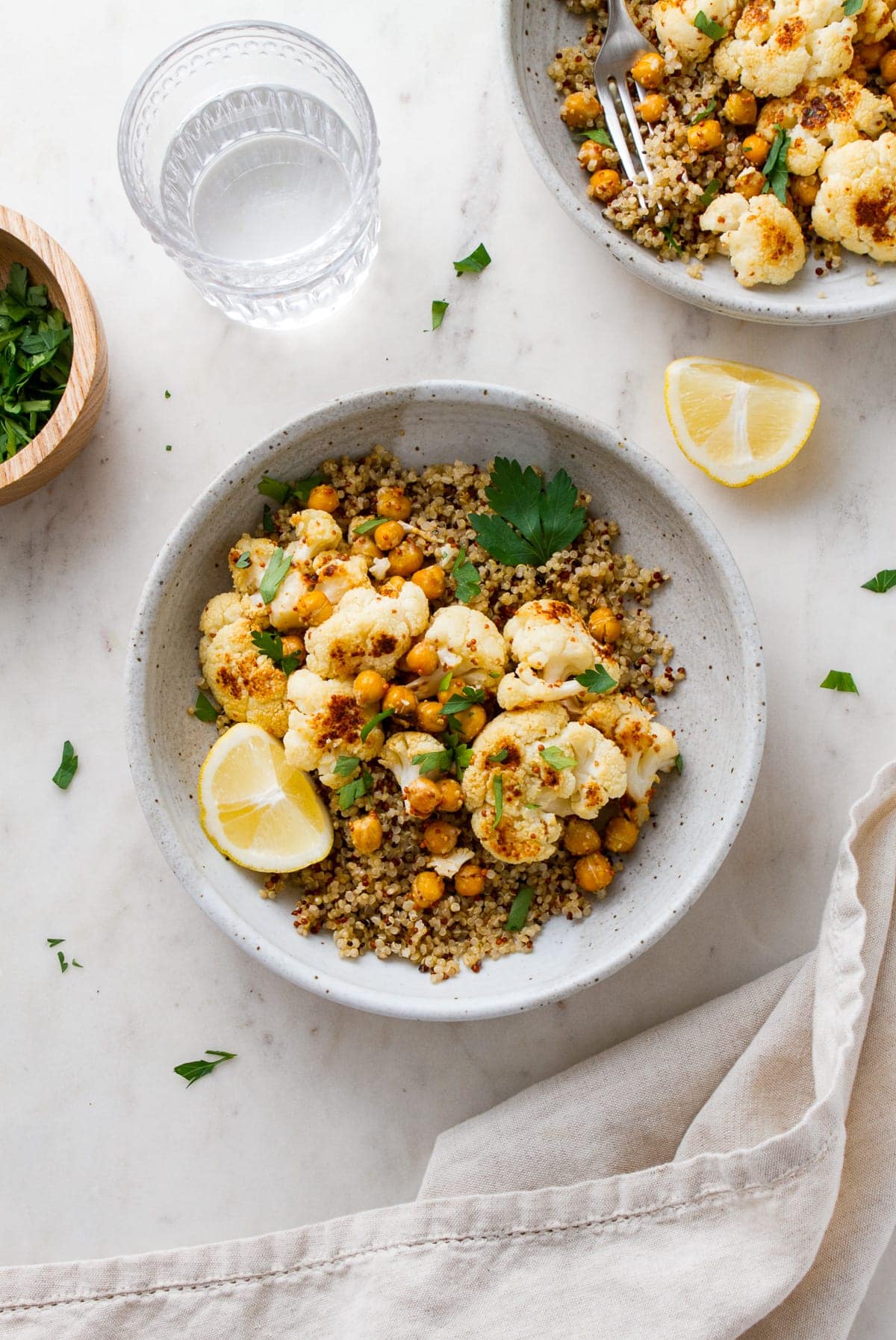 top down view of a bowl with a serving of quinoa, roasted cauliflower with mustard dressing and chickpeas.