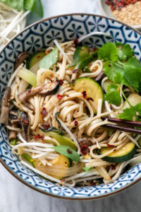 top down view of plated udon noodle bowl with items surrounding.