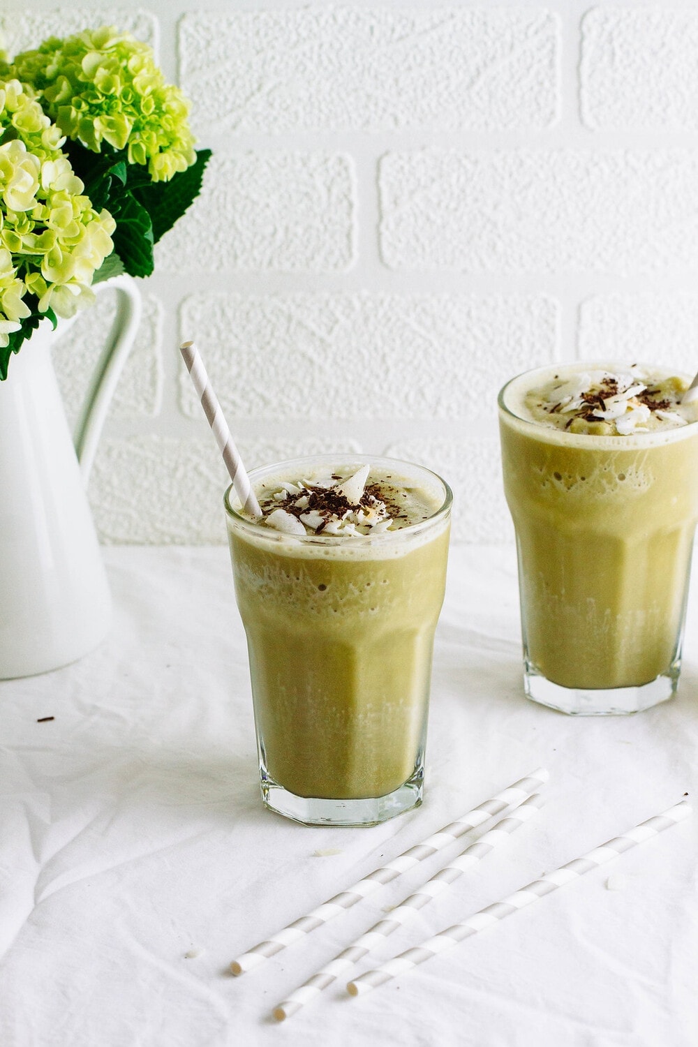 head on shot of 2 glass filled with vegan matcha milkshakes.